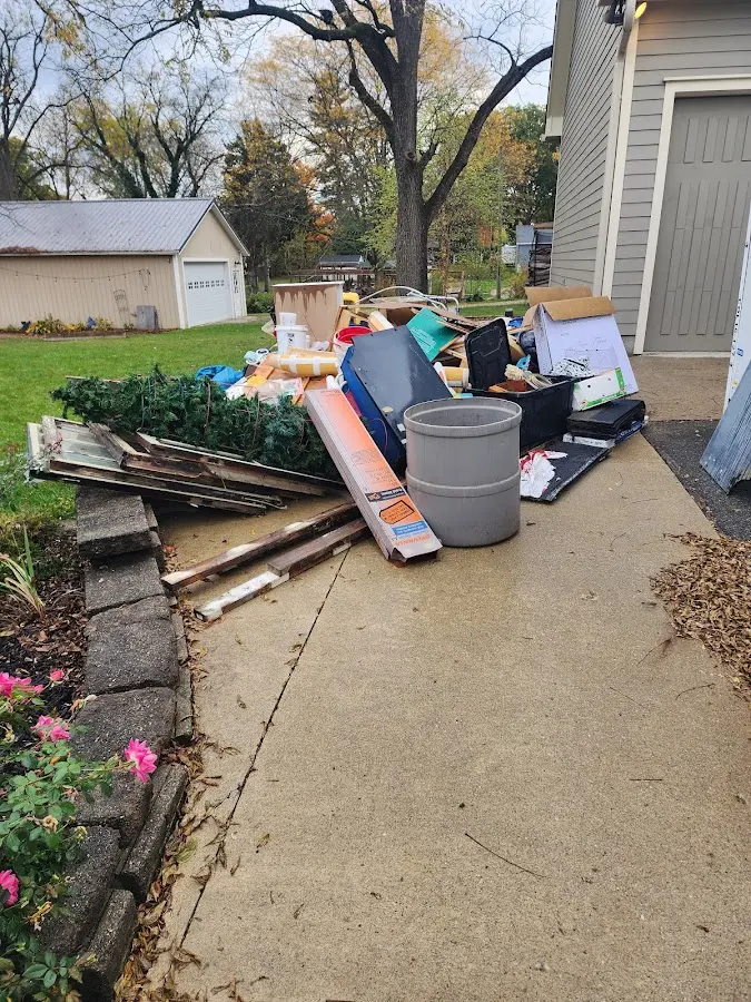 Dumpster being loaded with debris for Estate Cleanout Dumpster Rental in St. James